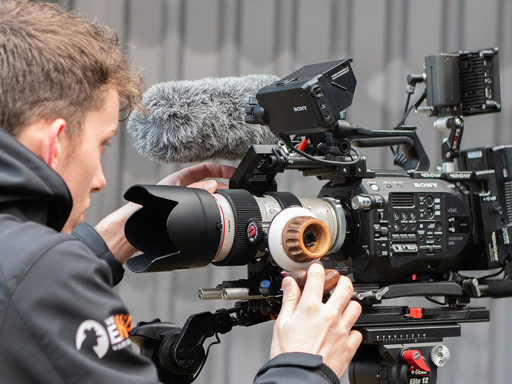Cameraman en filmmaker met Sony FS7 camera op een filmset in Veenendaal en Ede, actief bezig met het opnemen van een bedrijfsfilm, gericht op het vastleggen van hoogwaardige beelden in een professionele setting.