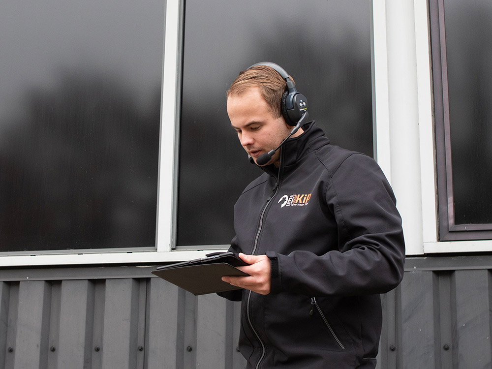 Producent Kevin Ike coördineert een filmproductie op locatie, waarbij hij de voortgang van de videoproductie zorgvuldig overziet en leidt