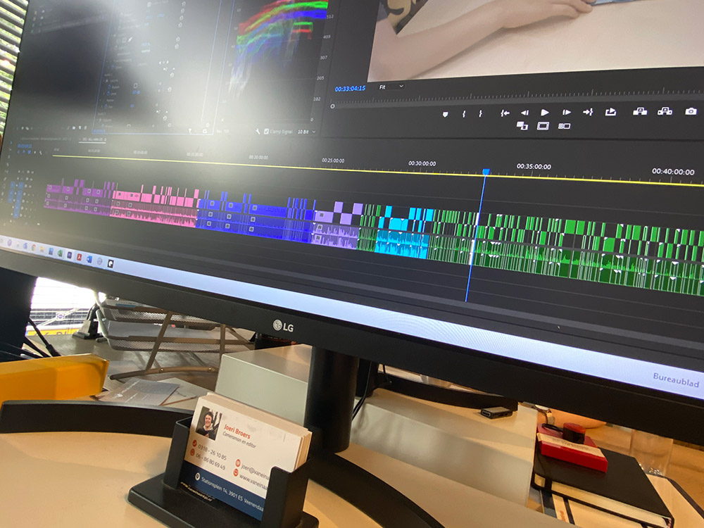 Video-editor aan het werk met videomontage en -bewerking voor een bedrijfsfilm, gebruikt Premiere Pro op een computer voor professionele afwerking
